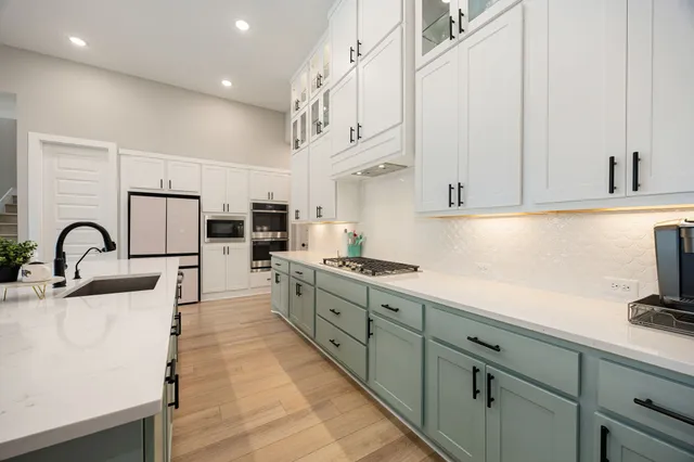 a kitchen with stainless steel appliances granite countertop a sink and cabinets