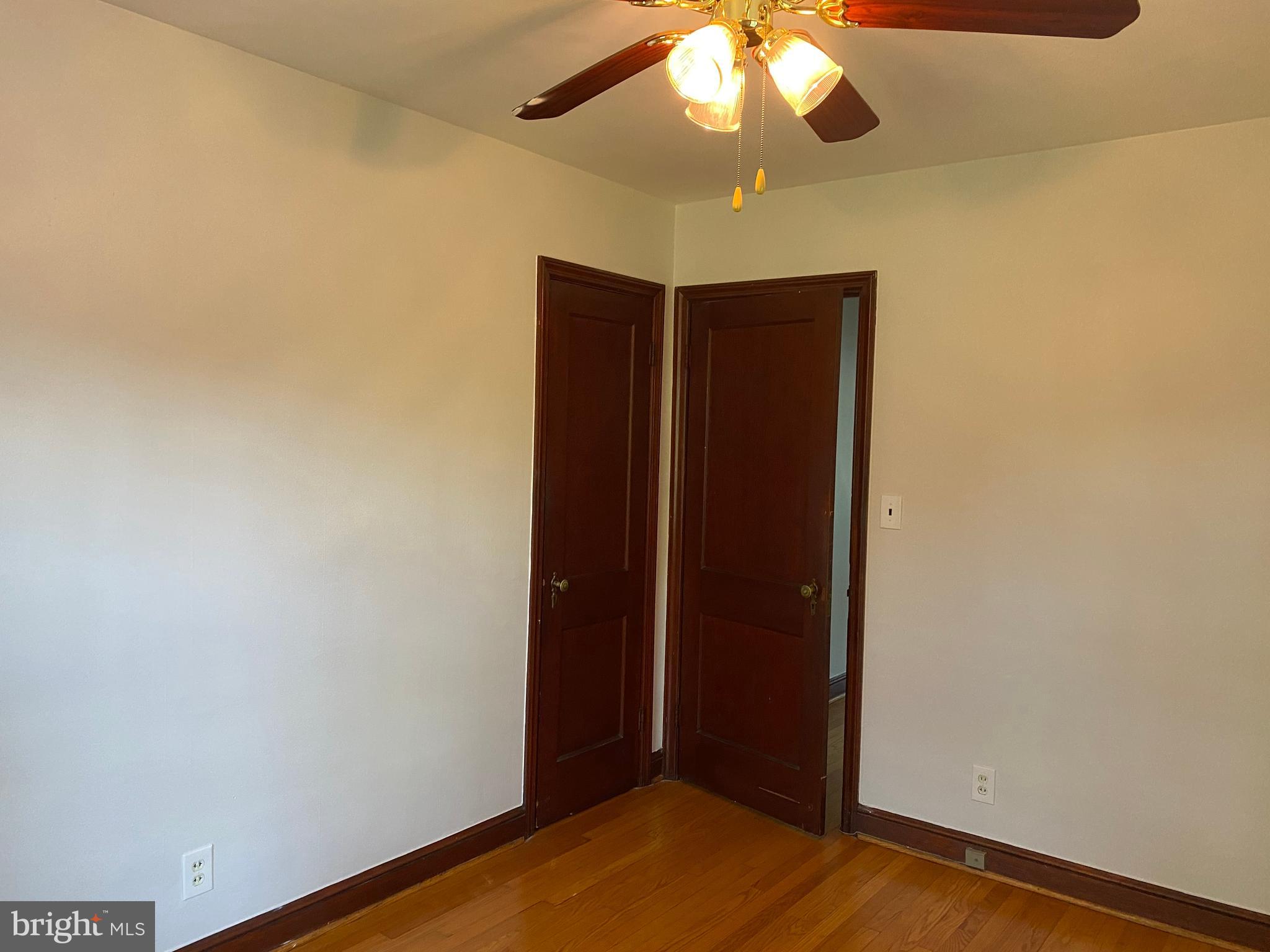 202 East Spring Street Alexandria, VA 22301 - Photo 15 of 45 an empty room with a chandelier fan and wooden floor