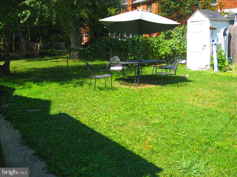202 East Spring Street Alexandria, VA 22301 - Photo 6 of 45 a view of a garden with chairs under an umbrella