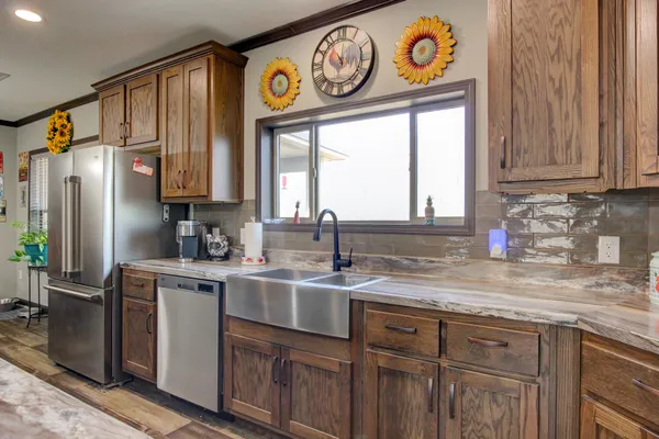 a kitchen with stainless steel appliances granite countertop a sink and a window