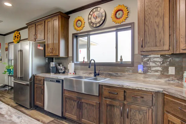 a kitchen with stainless steel appliances granite countertop a sink and a window