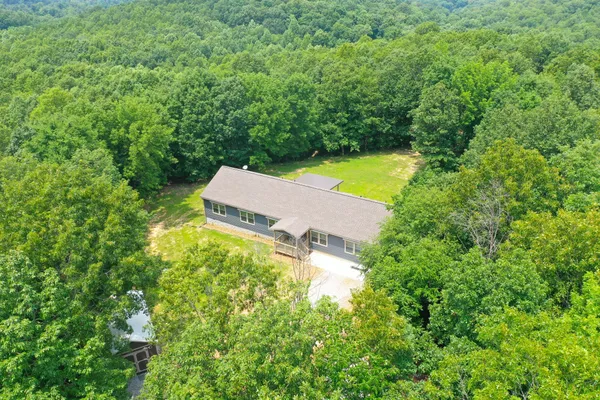 an aerial view of a house with a yard and lake view