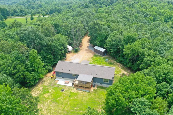 an aerial view of a house with a yard and trees