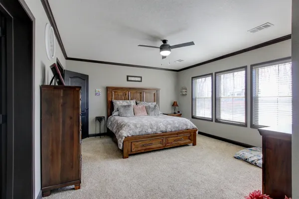 a bedroom with a bed chandelier and a window