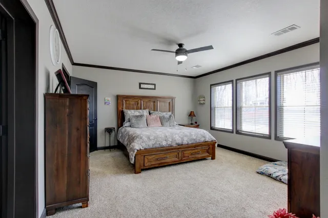 a bedroom with a bed chandelier and a window