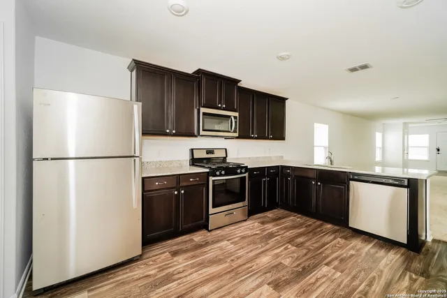 a kitchen with granite countertop stainless steel appliances and wooden cabinets