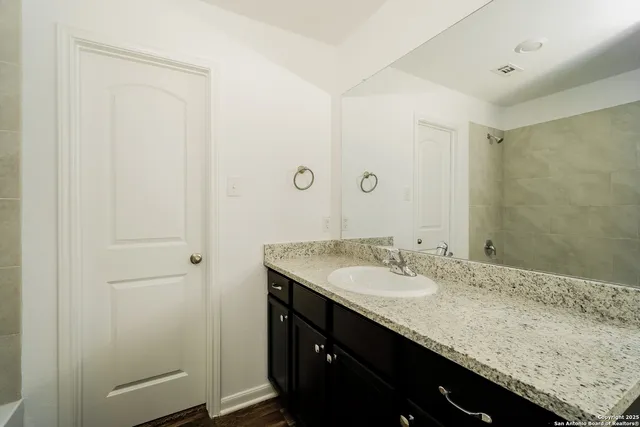 a bathroom with a granite countertop sink and a mirror