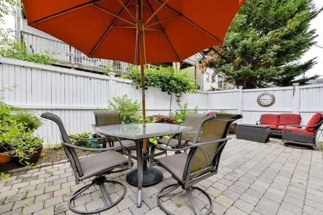 a patio with a table and chairs under an umbrella