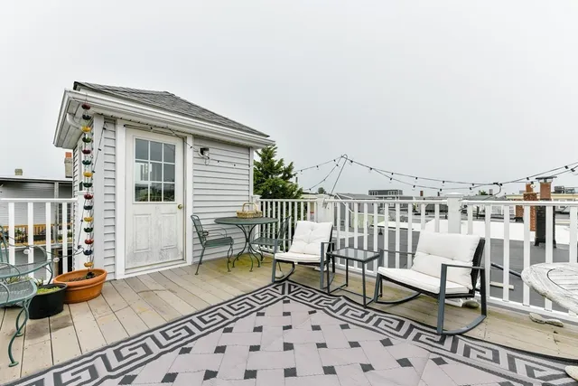 a balcony with chairs and wooden floor
