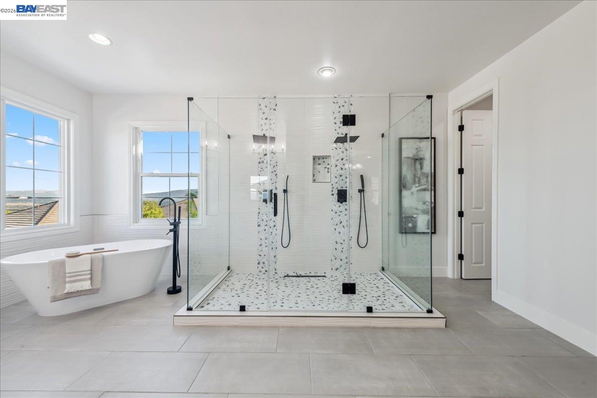 2890 Sable Oaks Way Dublin, CA 94568 - Photo 29 of 60 a bathroom with a tub a mirror and a shower