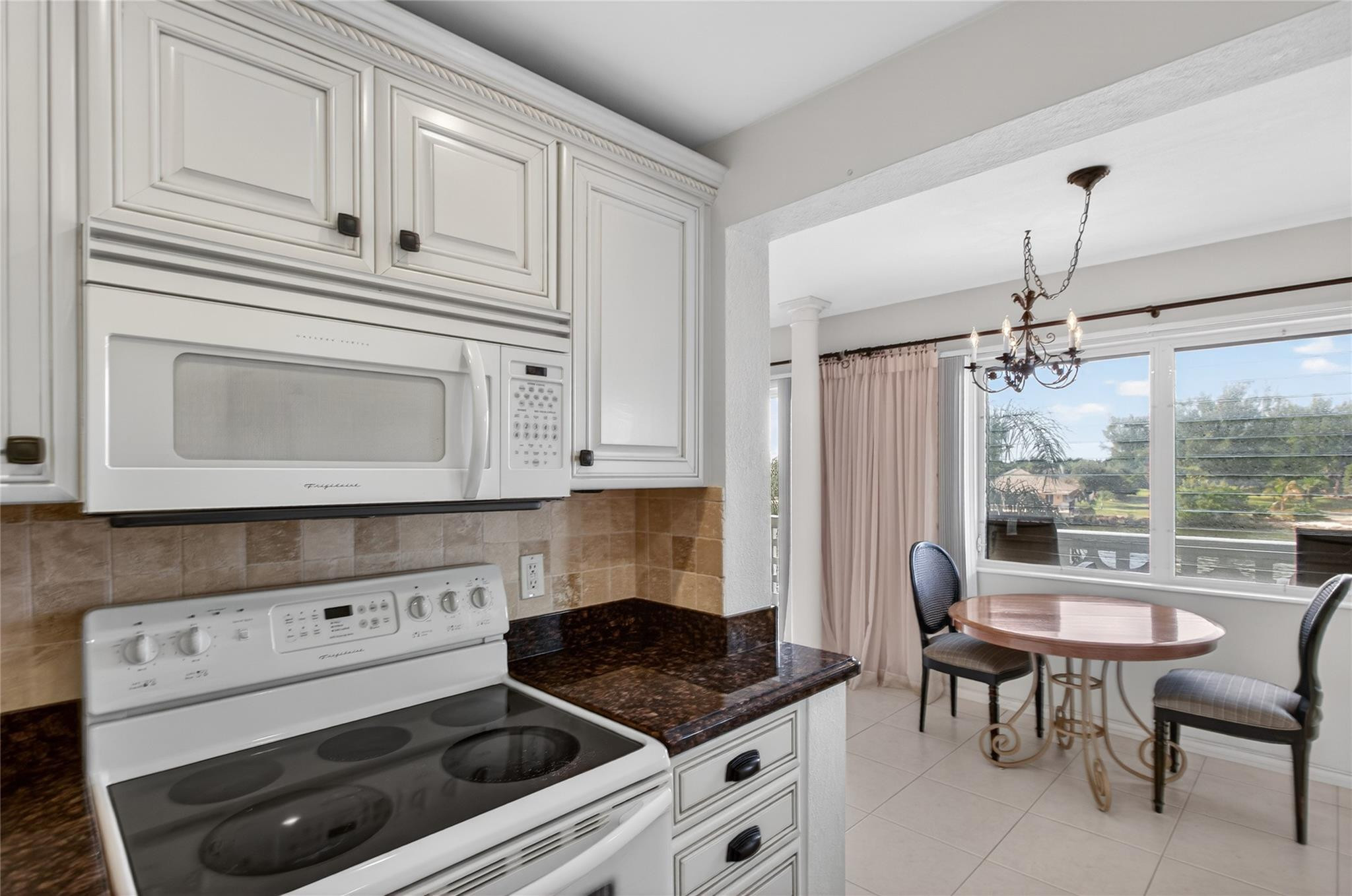 1001 North Riverside Drive, Unit 305 Pompano Beach, FL 33062 - Photo 19 of 44 a kitchen with granite countertop white cabinets and white appliances