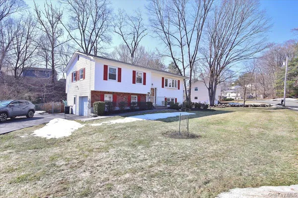 a front view of a house with a yard covered with snow