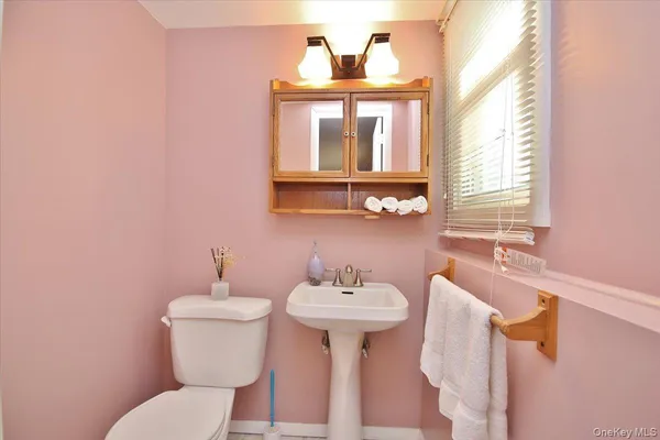 a bathroom with a sink mirror and toilet