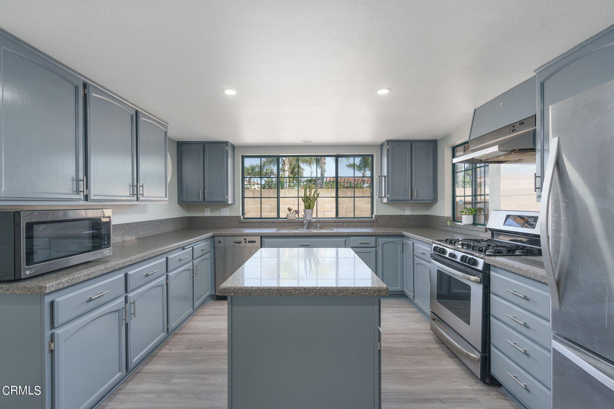 2940 Fanshell Walk Oxnard, CA 93035 - Photo 3 of 40 a kitchen with stainless steel appliances granite countertop a stove a sink and a microwave