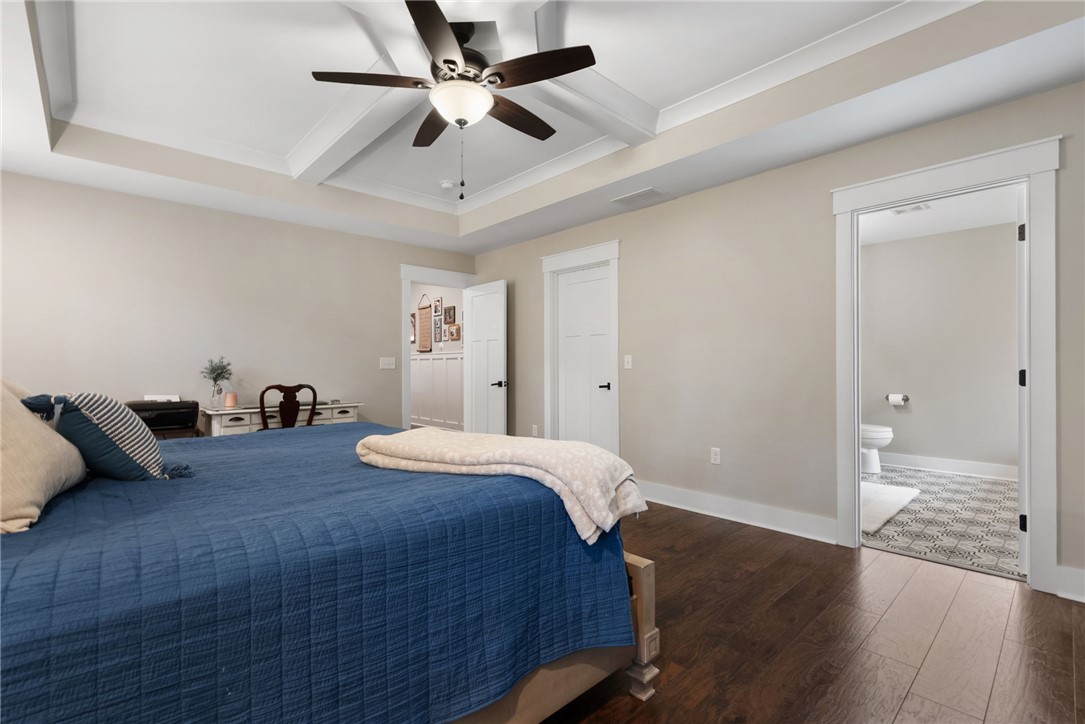 201 Hearthstone Drive Anderson, SC 29621 - Photo 29 of 49 This spacious bedroom features warm hardwood flooring, a multi-layered tray ceiling, and an adjoining bath with patterned tile.