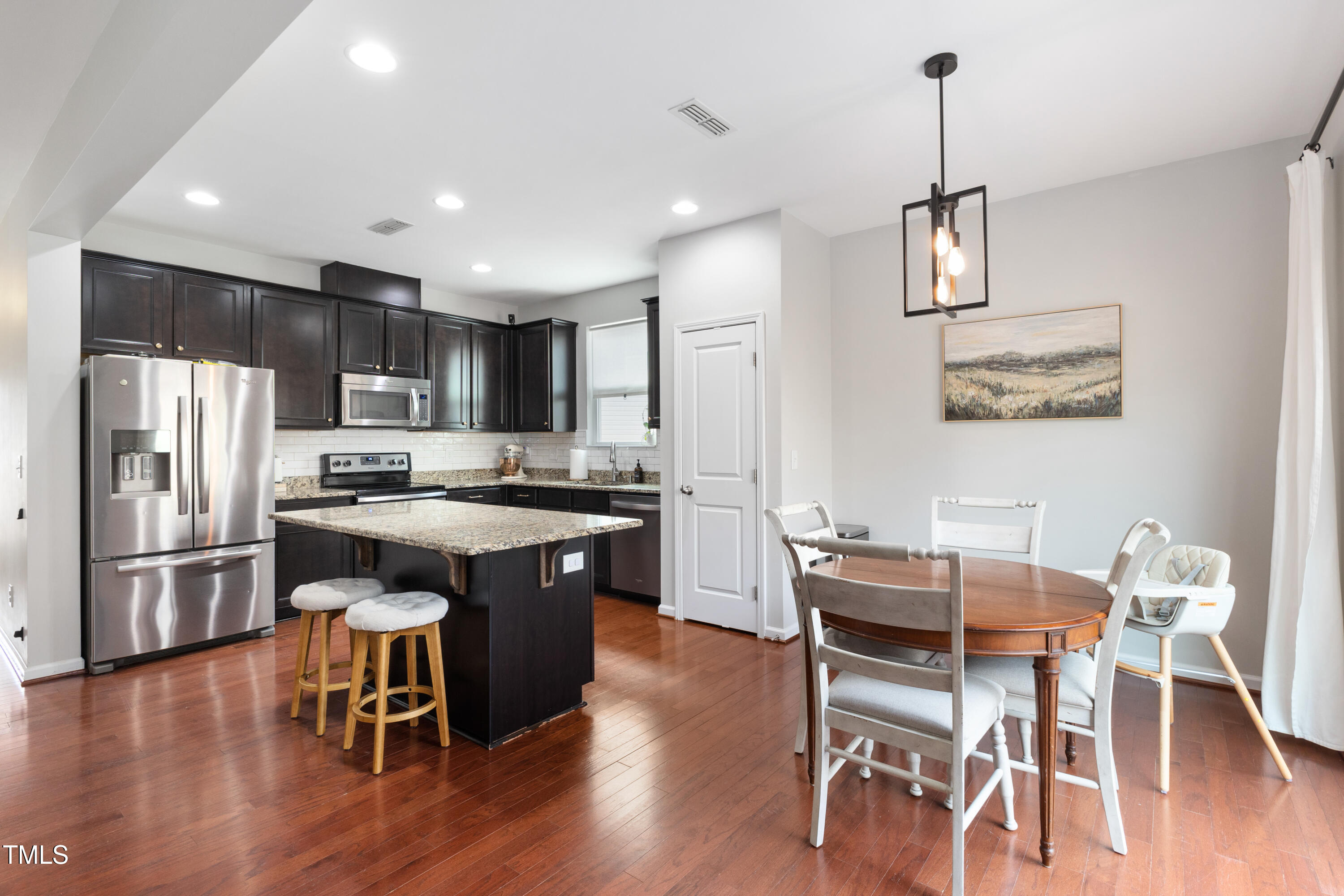 617 Hope Valley Road Knightdale, NC 27545 - Photo 11 of 42 a kitchen with stainless steel appliances granite countertop a table chairs refrigerator and microwave
