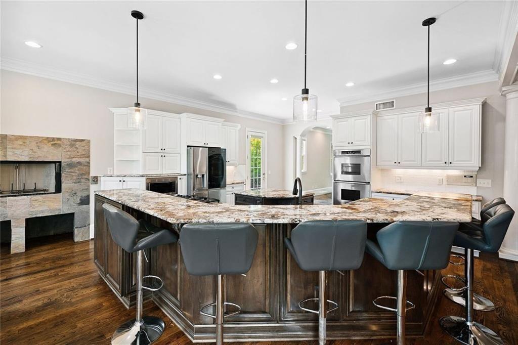 11140 W Road Roswell, GA 30075 - Photo 17 of 72 a kitchen with kitchen island granite countertop a sink a center island stainless steel appliances and cabinets