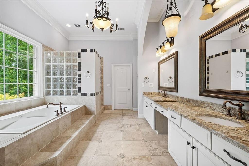 11140 W Road Roswell, GA 30075 - Photo 34 of 72 a spacious bathroom with sinks granite countertop tub a double vanity sink a window and a mirror