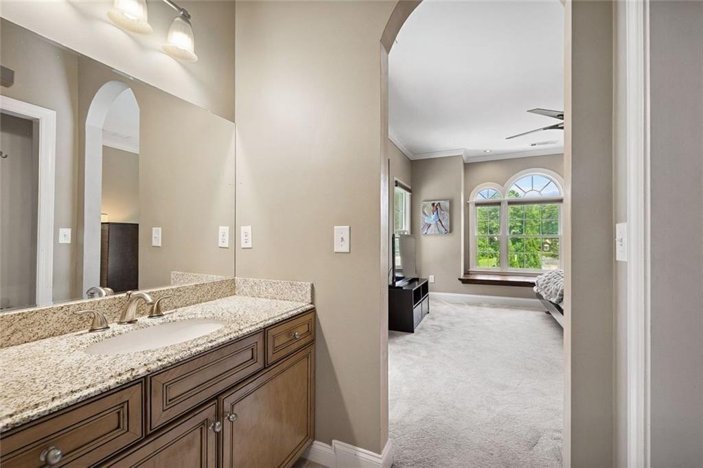 11140 W Road Roswell, GA 30075 - Photo 37 of 72 a bathroom with a granite countertop sink a toilet and a large mirror
