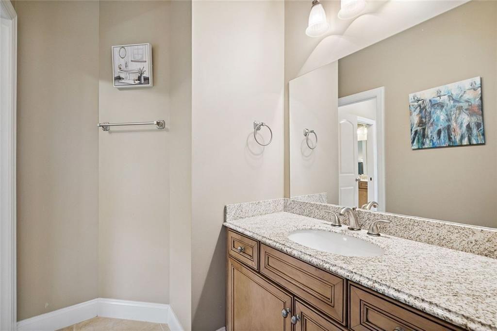 11140 W Road Roswell, GA 30075 - Photo 39 of 72 a bathroom with a granite countertop sink toilet and a mirror