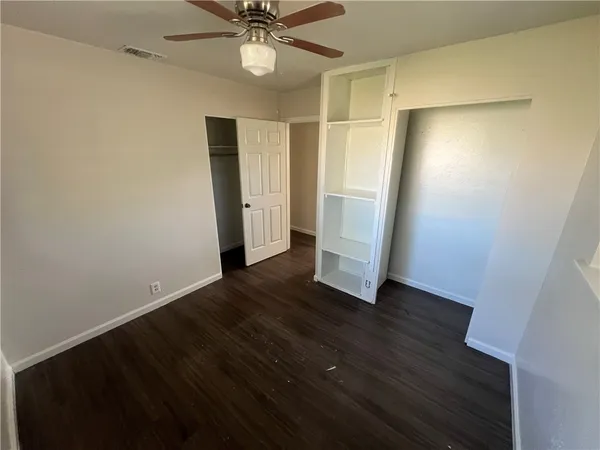 an empty room with wooden floor and white walls