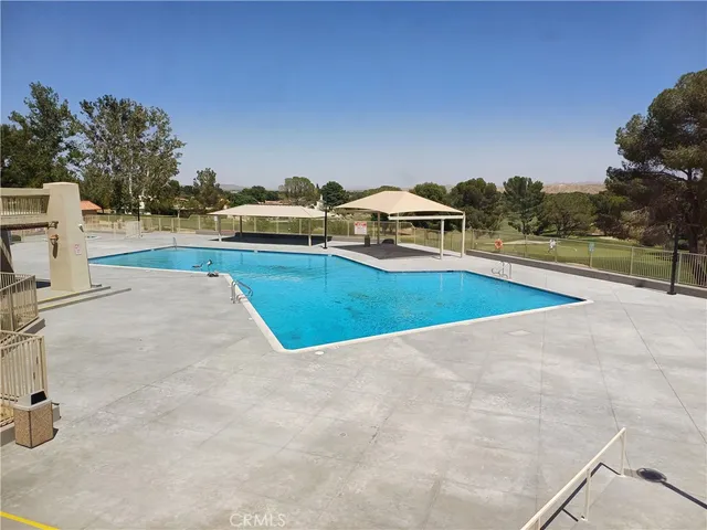 a swimming pool with a yard and seating area