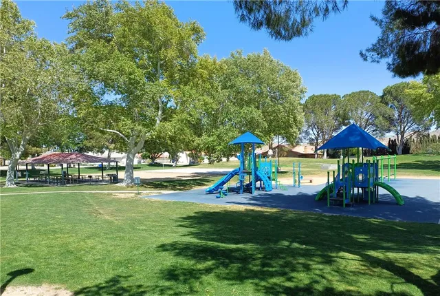 a view of a swimming pool with lawn chairs and a big yard