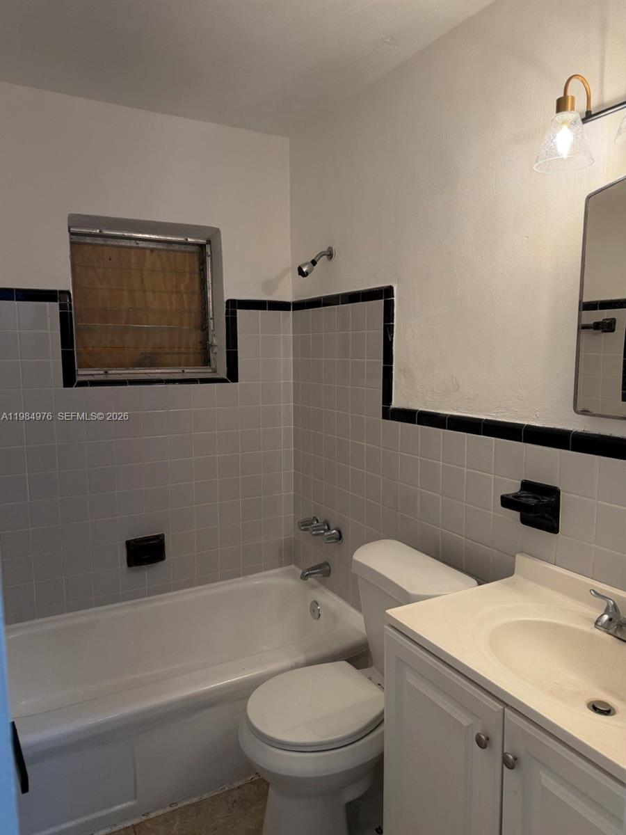 2335 Northwest 68th Street, Unit 1 Miami, FL 33147 - Photo 4 of 12 a bathroom with a toilet a sink and bathtub