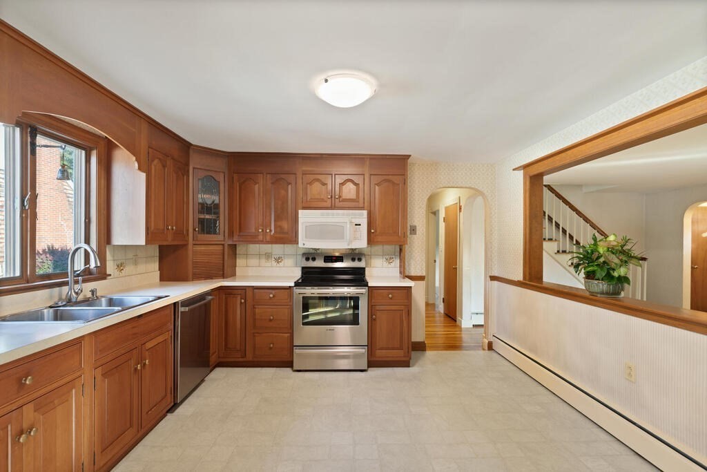 16 Surrey Road Salem, MA 01970 - Photo 17 of 32 a kitchen with stainless steel appliances granite countertop a stove top oven a sink and dishwasher a refrigerator with wooden floor