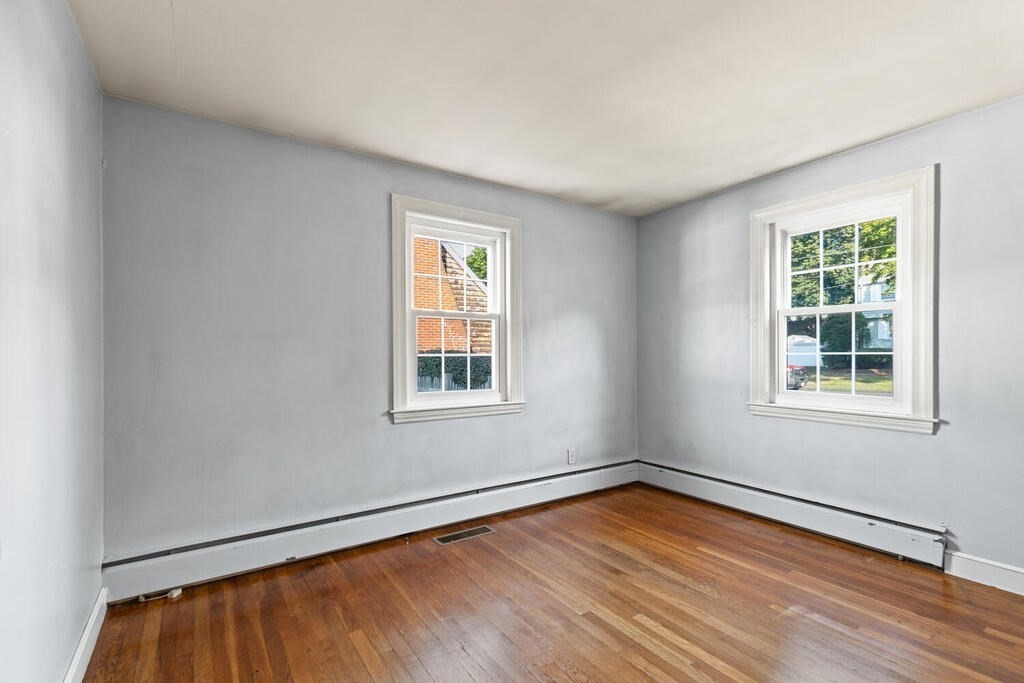 16 Surrey Road Salem, MA 01970 - Photo 21 of 32 an empty room with wooden floor and windows