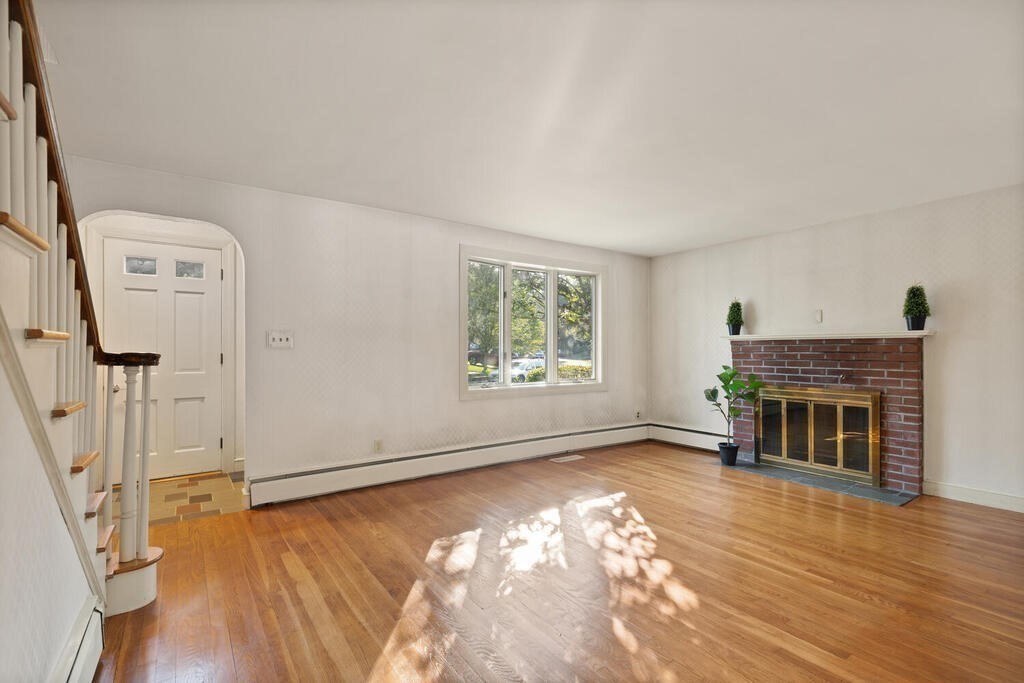 16 Surrey Road Salem, MA 01970 - Photo 6 of 32 an empty room with windows fireplace and wooden floor