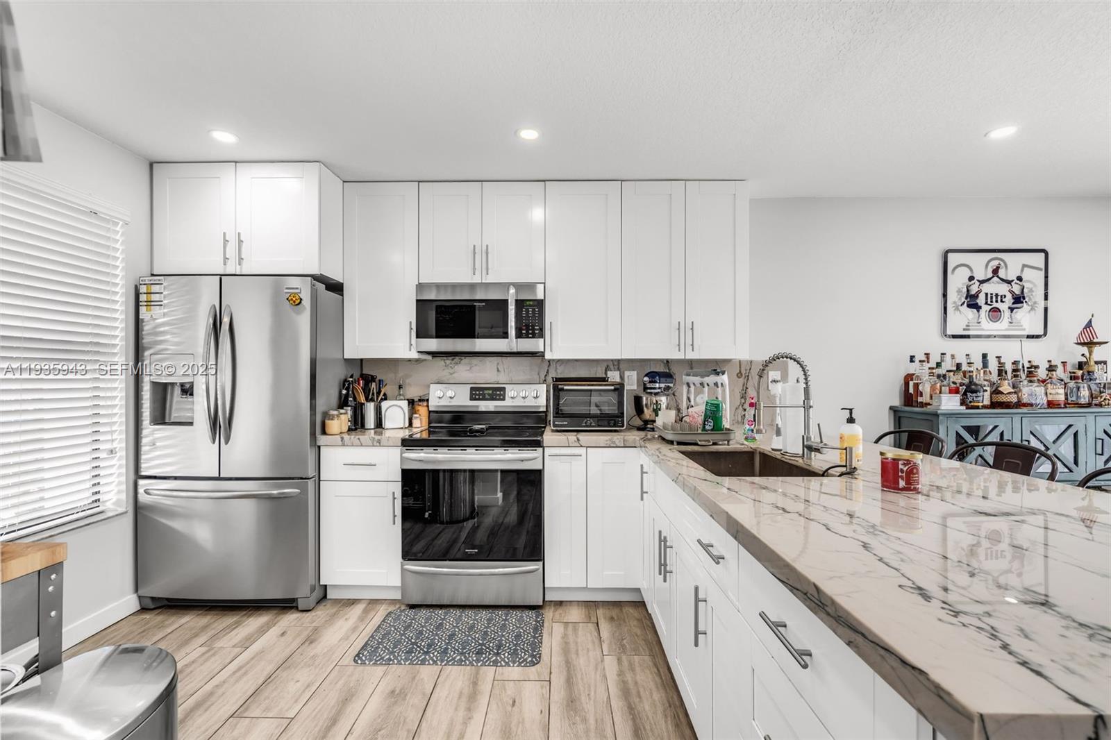 12950 Southwest 66th Terrace, Unit 12950 Miami, FL 33183 - Photo 3 of 16 a kitchen with a refrigerator stove and sink with wooden floor