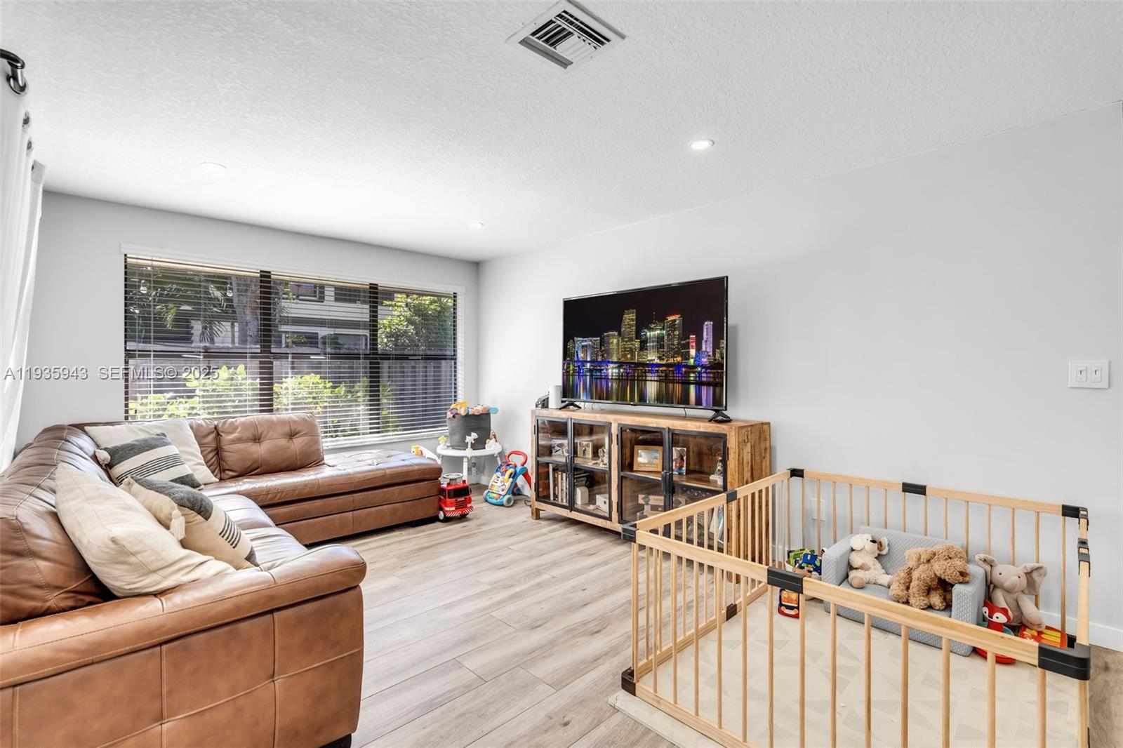 12950 Southwest 66th Terrace, Unit 12950 Miami, FL 33183 - Photo 6 of 16 a living room with furniture and a flat screen tv