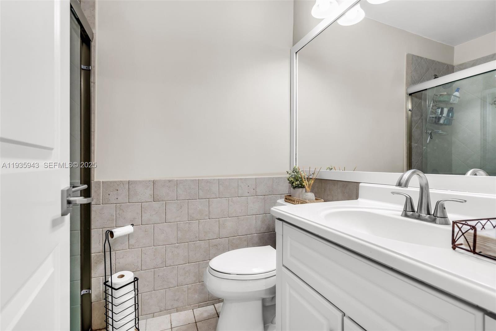 12950 Southwest 66th Terrace, Unit 12950 Miami, FL 33183 - Photo 10 of 16 a bathroom with a sink a toilet and a mirror