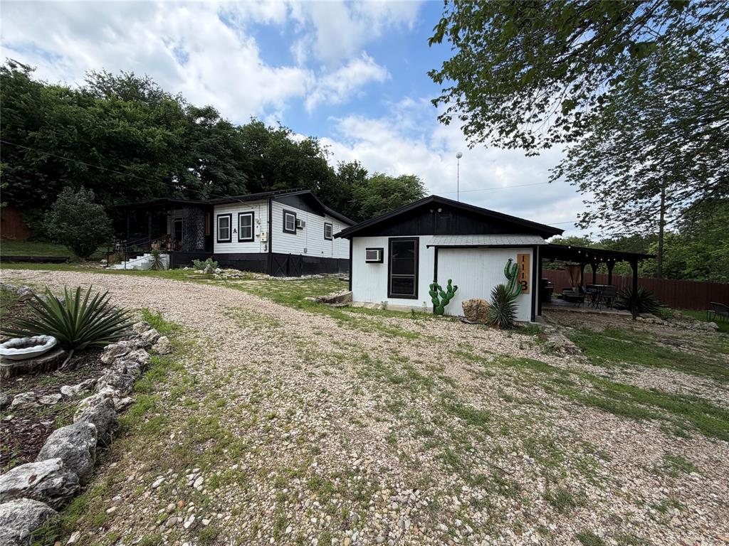 111 Apache Trail Whitney, TX 76692 - Photo 2 of 40 a front view of a house with a garden
