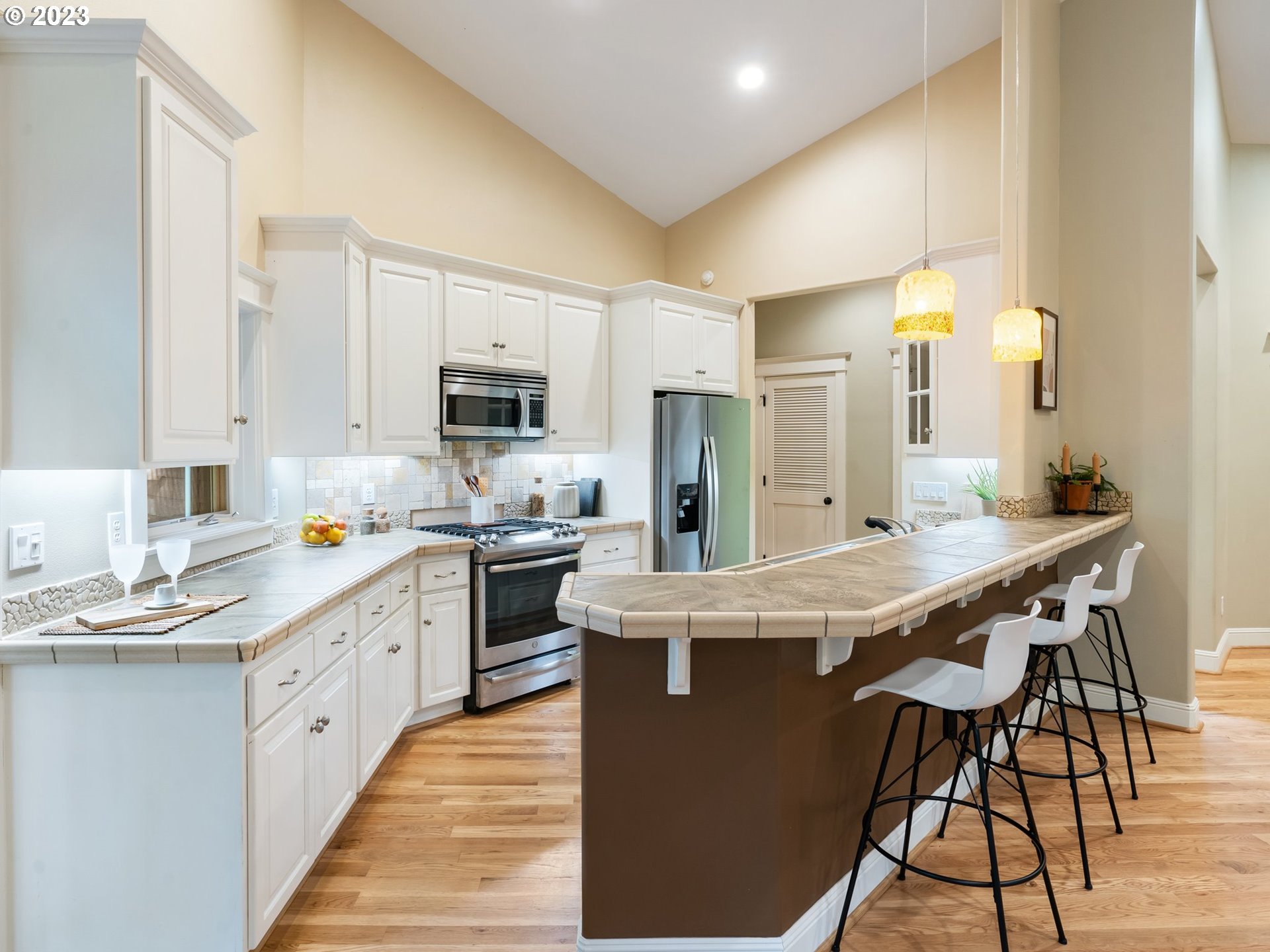 4410 West Burnside Road Portland, OR 97210 - Photo 11 of 42 a large kitchen with stainless steel appliances kitchen island granite countertop a sink and cabinets