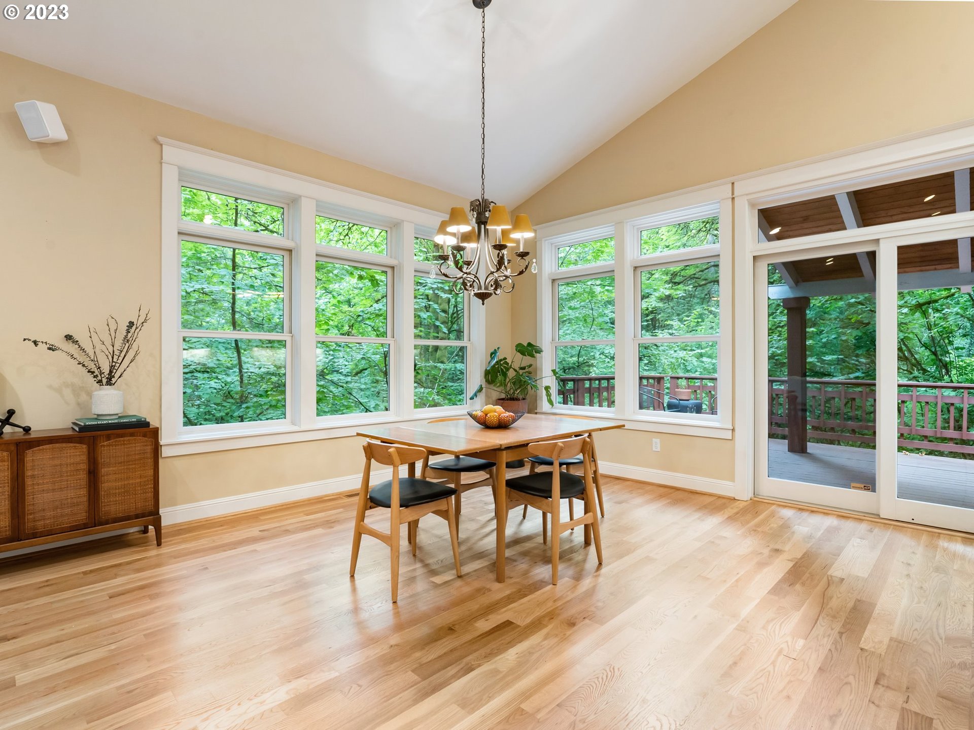 4410 West Burnside Road Portland, OR 97210 - Photo 8 of 42 a dining room with wooden floor a chandelier a flat screen tv and a large window