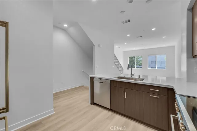 a view of cabinets a sink and wooden floor