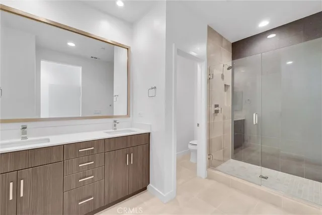 a bathroom with a shower tub double vanity sink and mirror