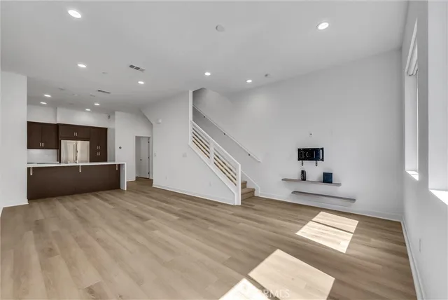 a view of kitchen and hall with wooden floor and a front door