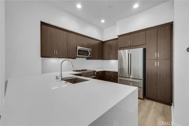 a kitchen with a refrigerator a microwave a sink and cabinets