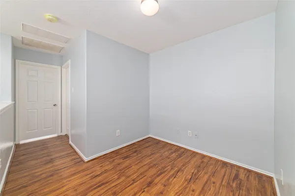 a view of a room with wooden floor and white walls