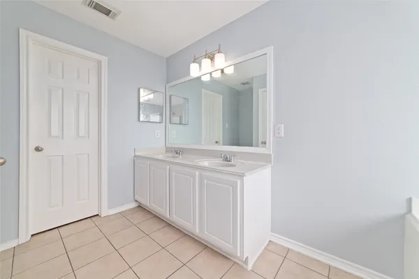 a bathroom with a double vanity sink and a mirror