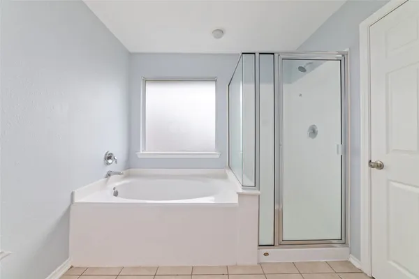 a white bath tub sitting in a bathroom and a shower