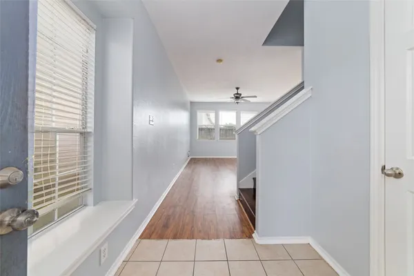 a view of a hallway with wooden floor and a bathroom