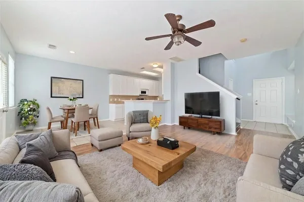 a living room with furniture and a flat screen tv with wooden floor