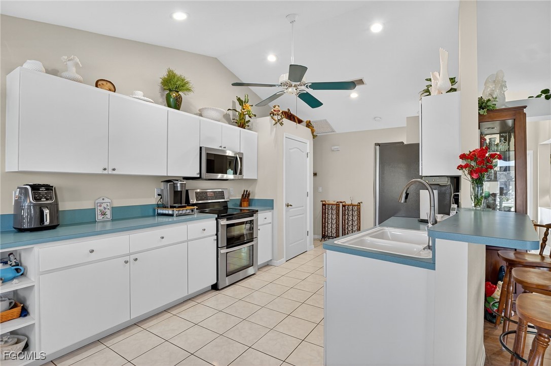 4306 Southwest 3rd Avenue Cape Coral, FL 33914 - Photo 12 of 50 a kitchen with granite countertop a sink stainless steel appliances and white cabinets