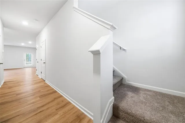 a view of a hallway with wooden floor and staircase