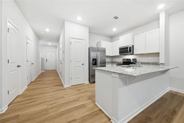 a view of kitchen with sink microwave and refrigerator