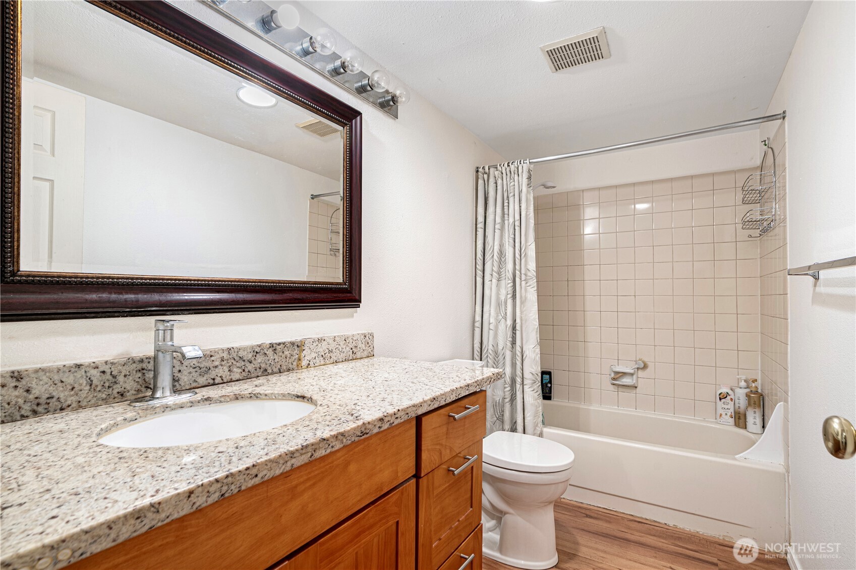 611 Southwest 5th Court, Unit A206 Renton, WA 98057 - Photo 18 of 21 a bathroom with a granite countertop sink toilet mirror and bathtub